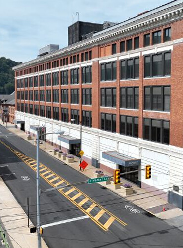 A classic brick commercial building on a city street corner, showcasing Omega Maintenance Solutions' expertise in commercial property management